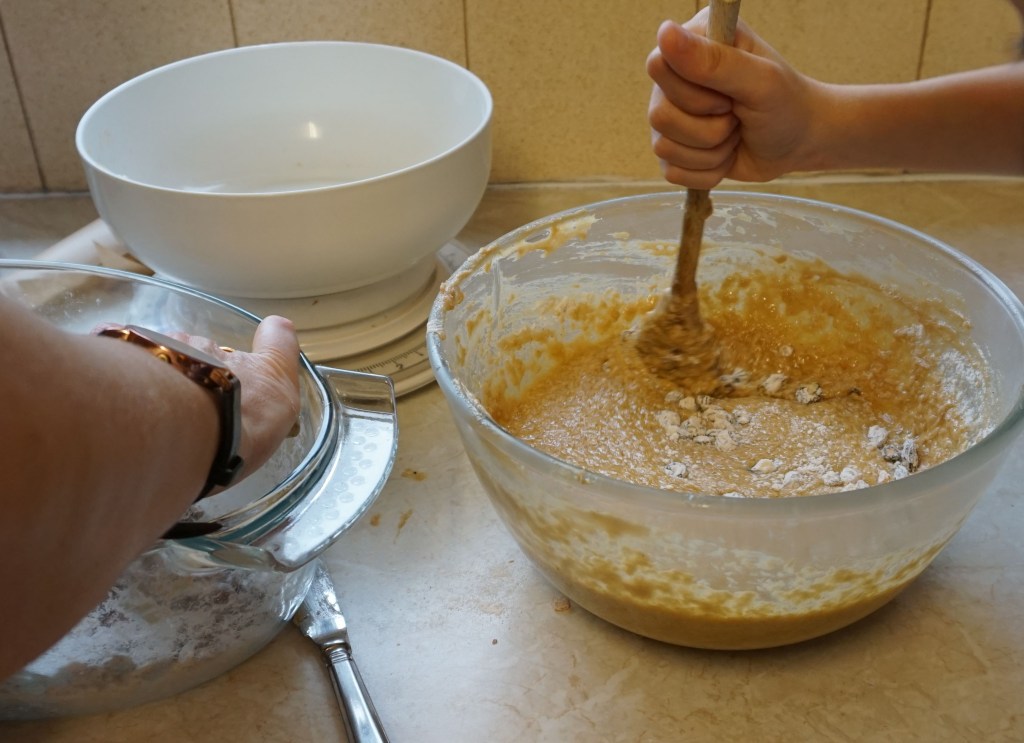 starting to add the fruit and flour mix to the butter, sugar and eggs